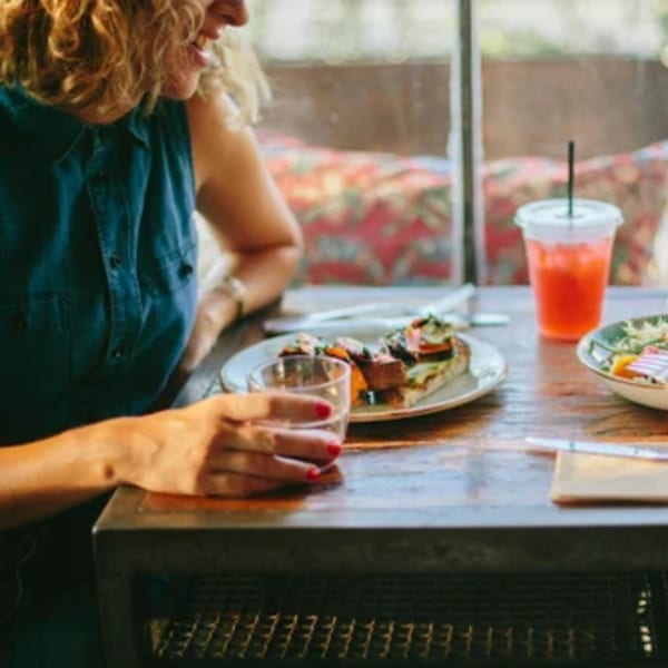 A woman enjoying a meal and drink at a table in Paper or Plastik Cafe.